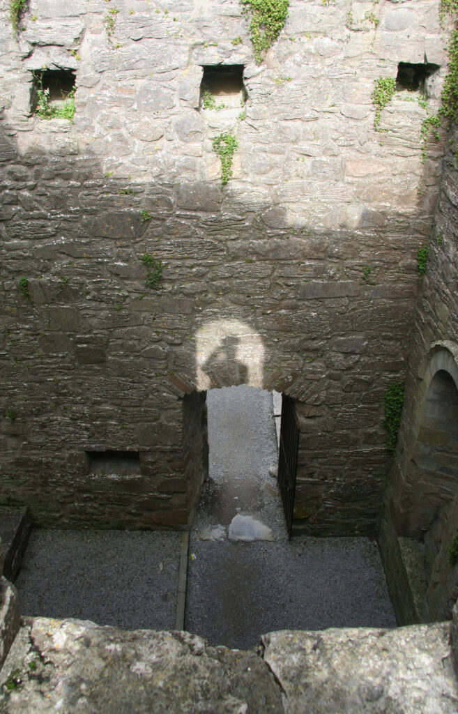 My shadow, on the wall of a castle in Ireland, wearing a silly hat.