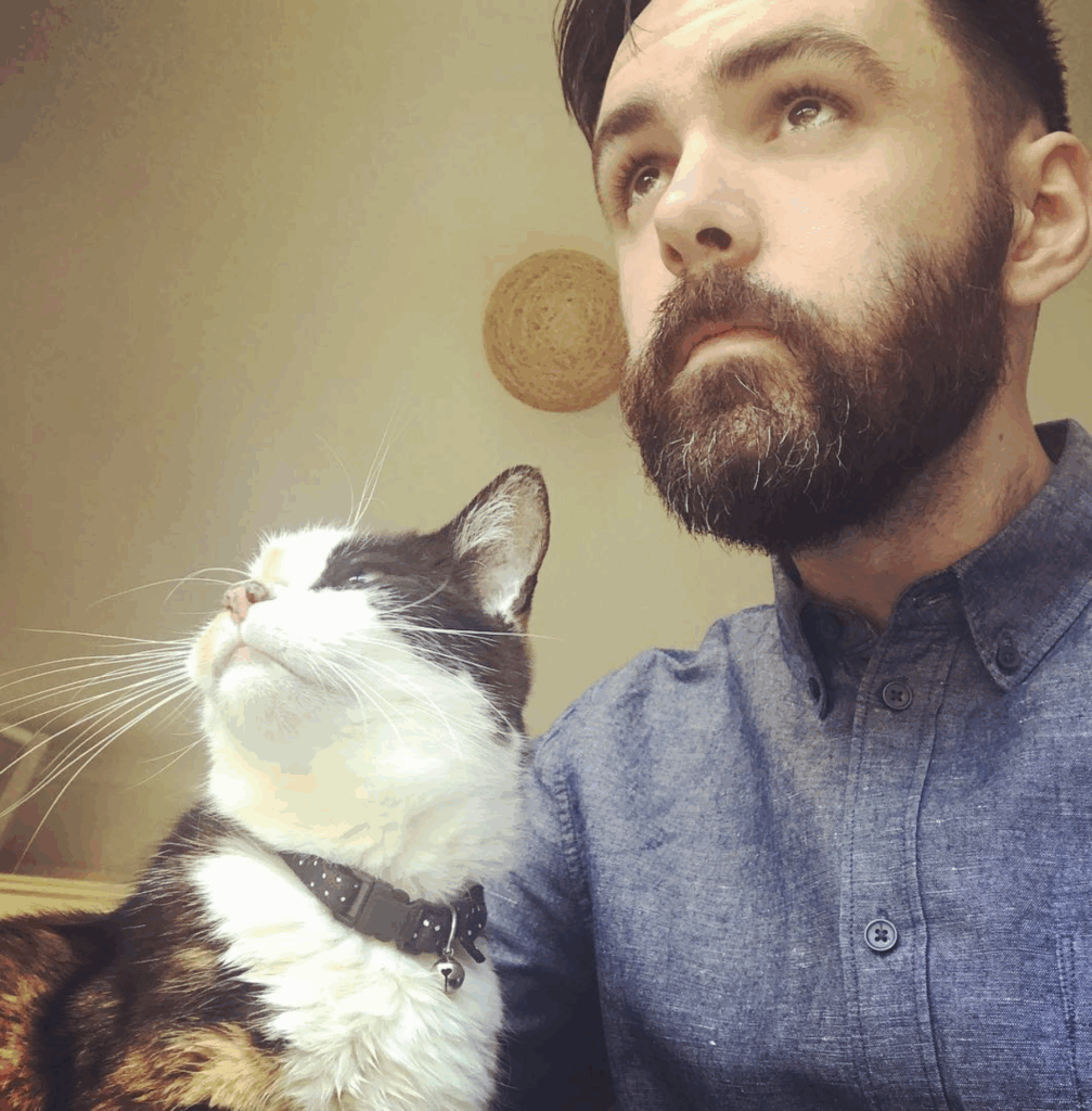 Will with his late cat Leela, looking off into the distance together.