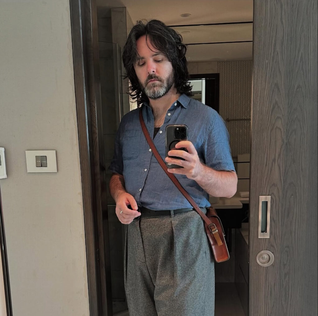 Will, in a doorway and high-waisted pants.