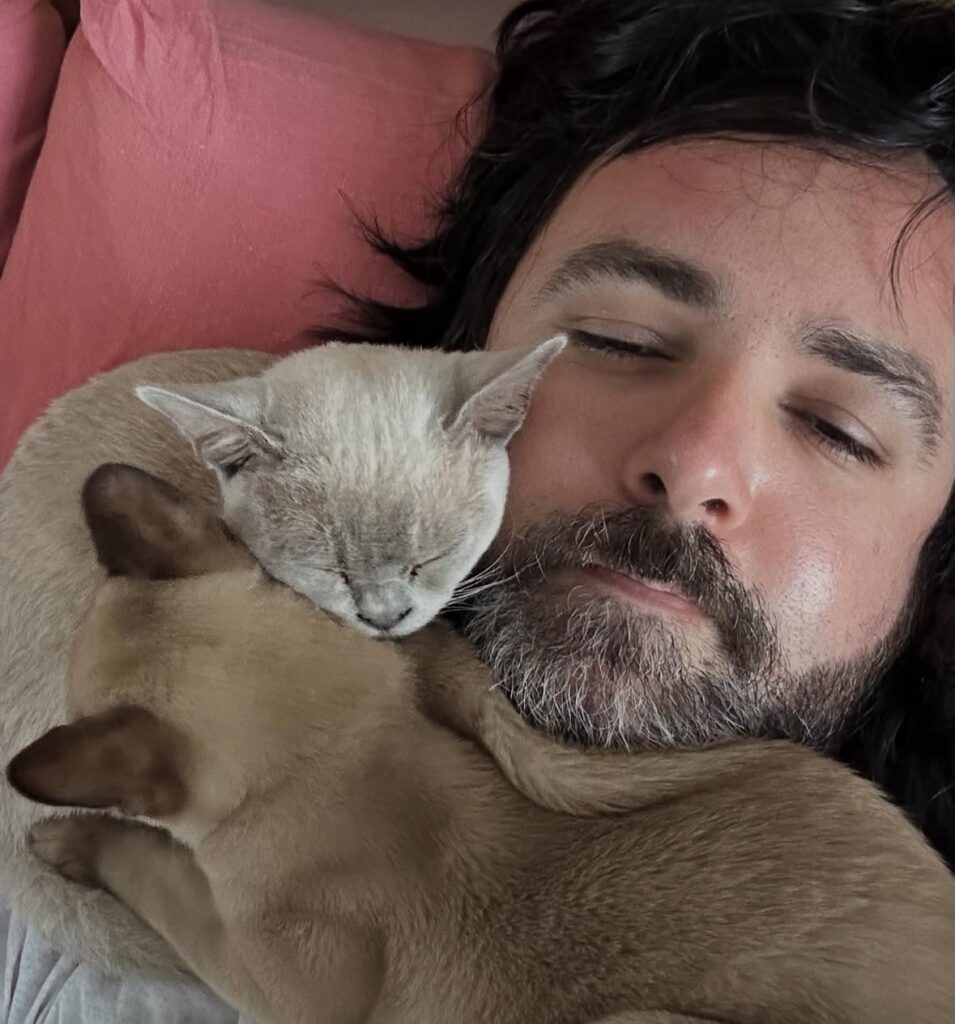 Will being lightly smothered by his cats Budino and Tortina.