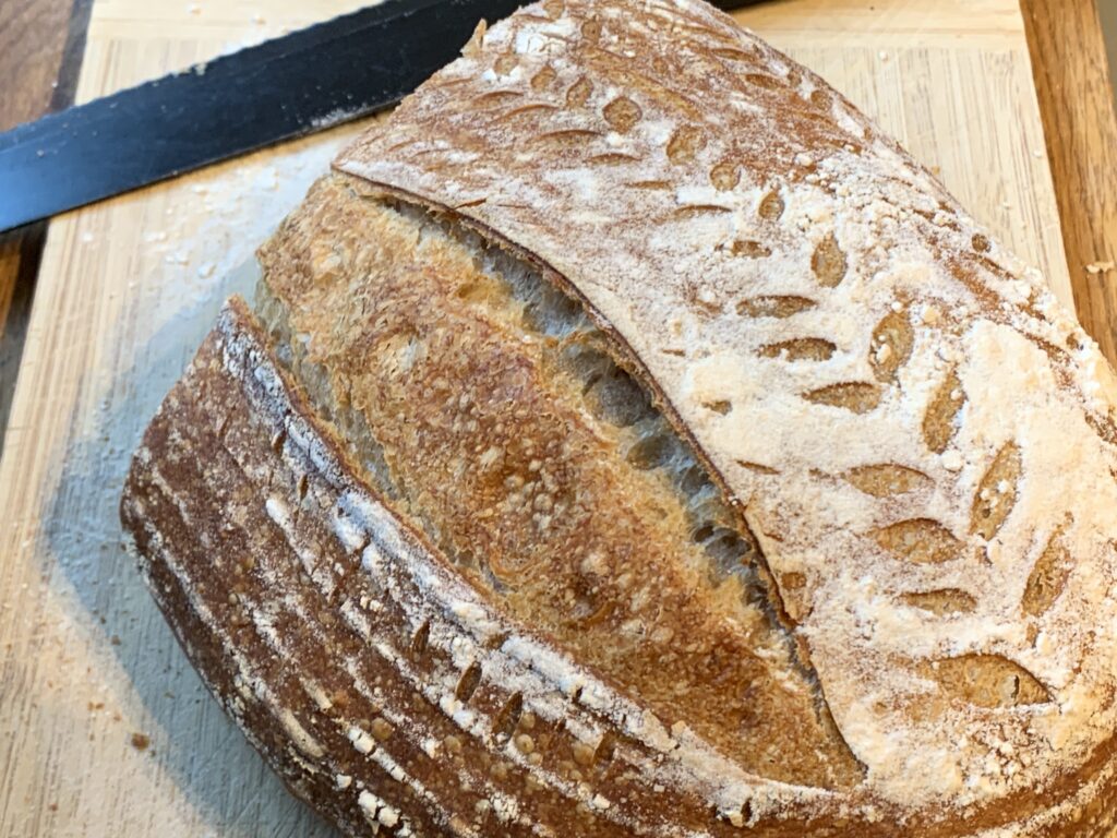 A top-down view of one of my very first really successful loaves, showing where the crust has split longitudinally with a wheat-stalk scoring pattern alongside the fissure.